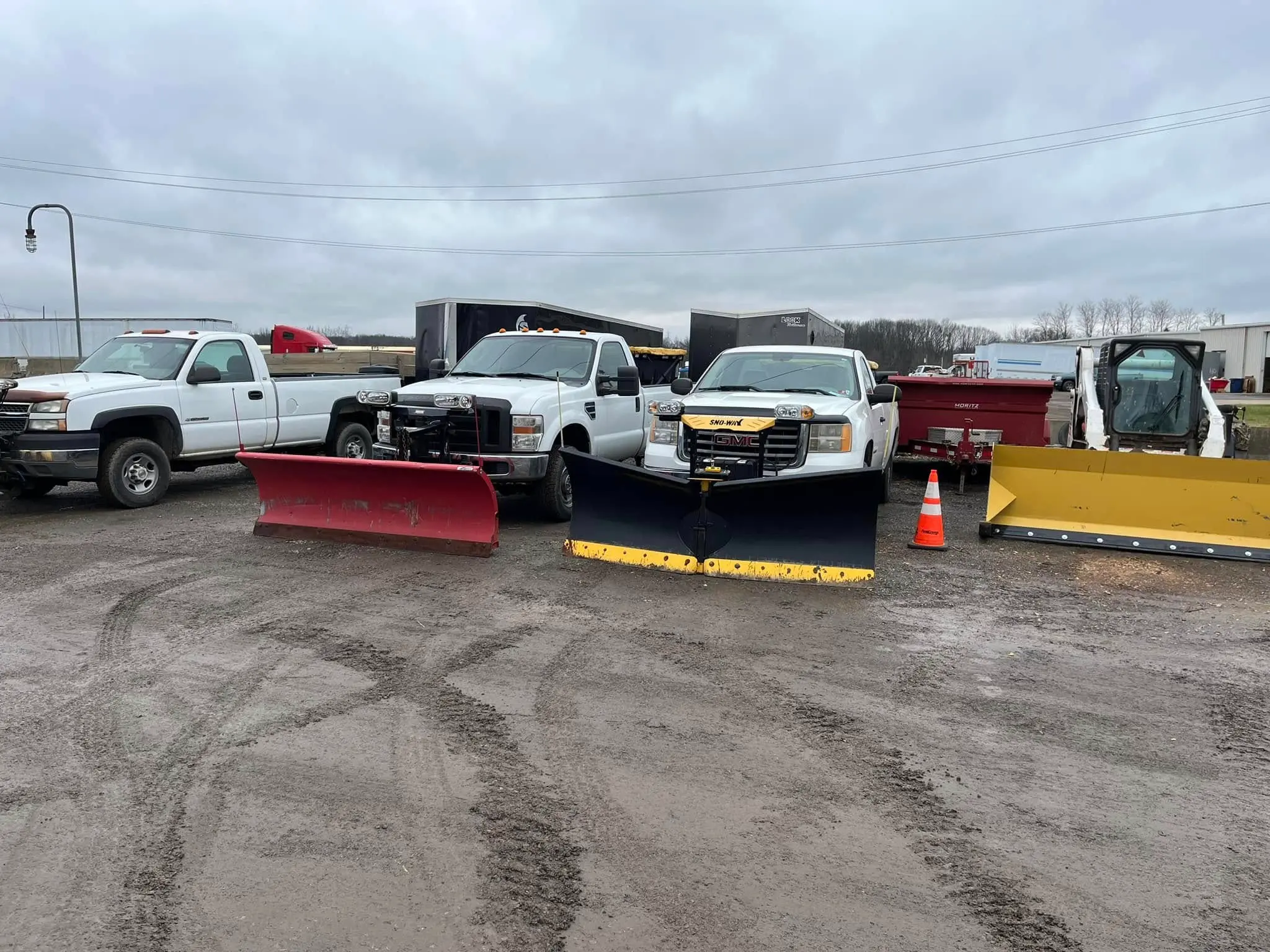 Commercial snow removal trucks and plow equipment prepared for winter service
