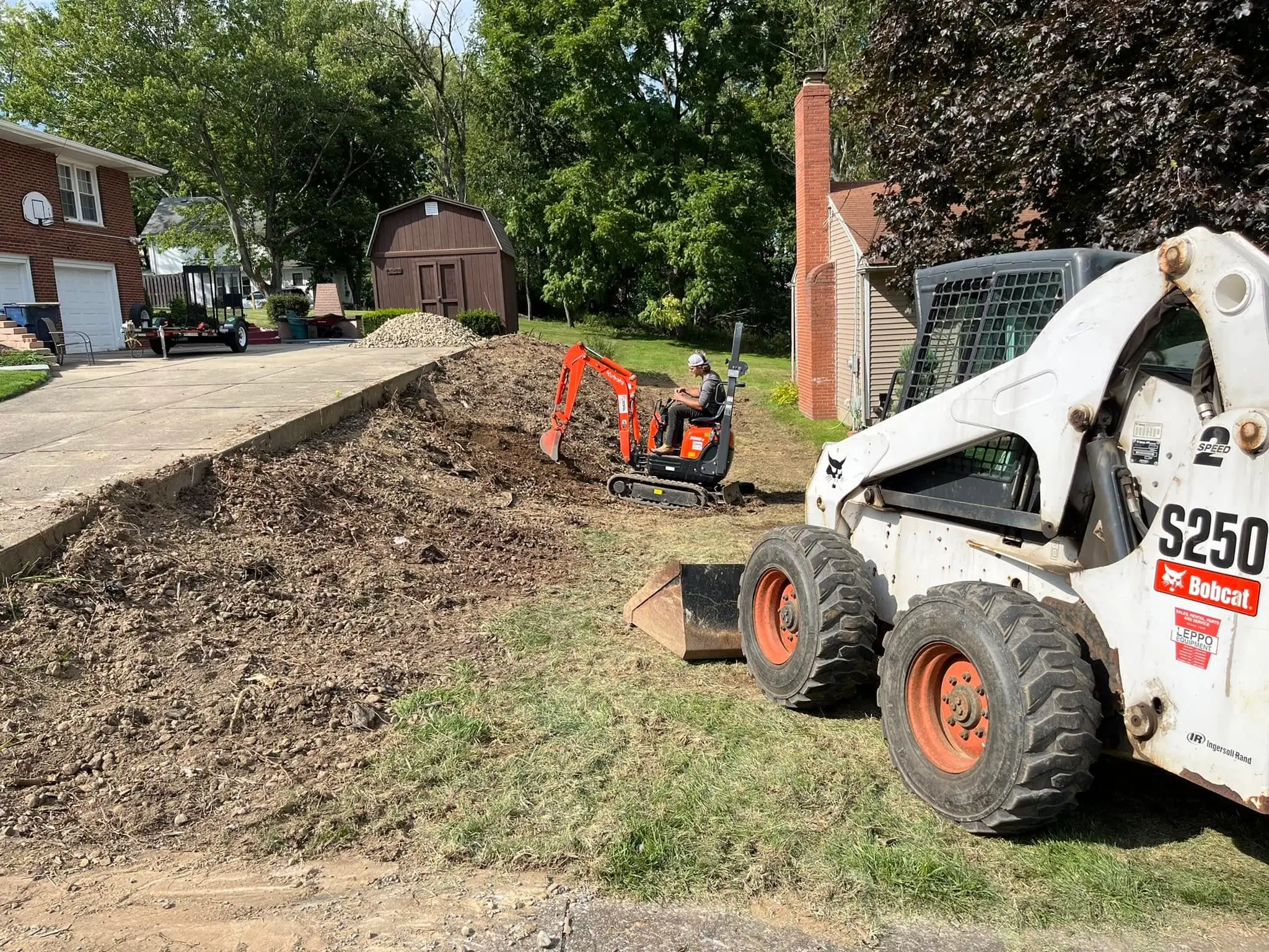 Excavation equipment performing site preparation and grading for residential property