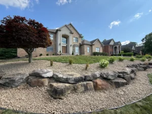 Front yard with decorative rock border and clean landscape installation along slope