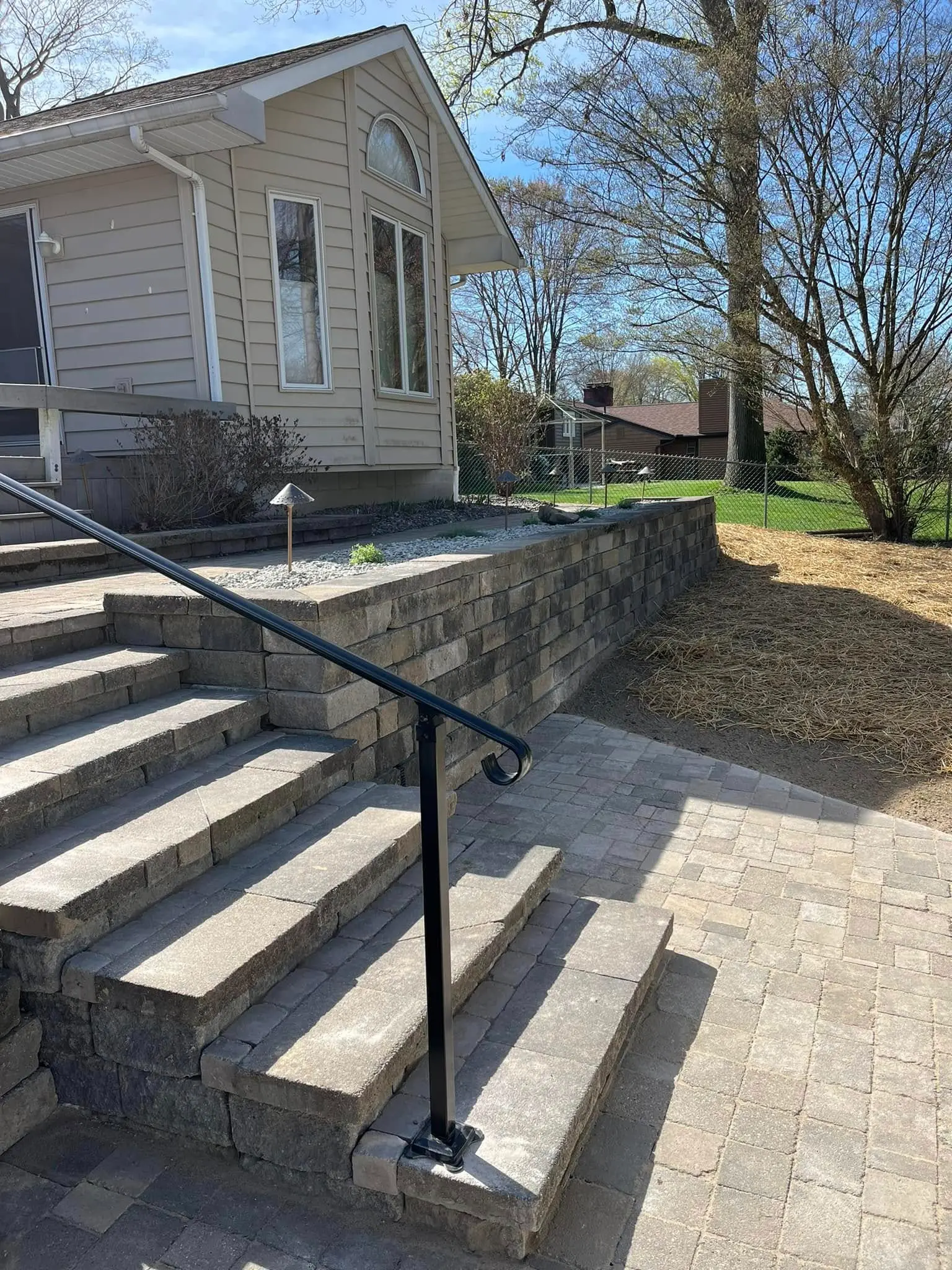 Paver patio and retaining wall installation with steps and clean stone finish