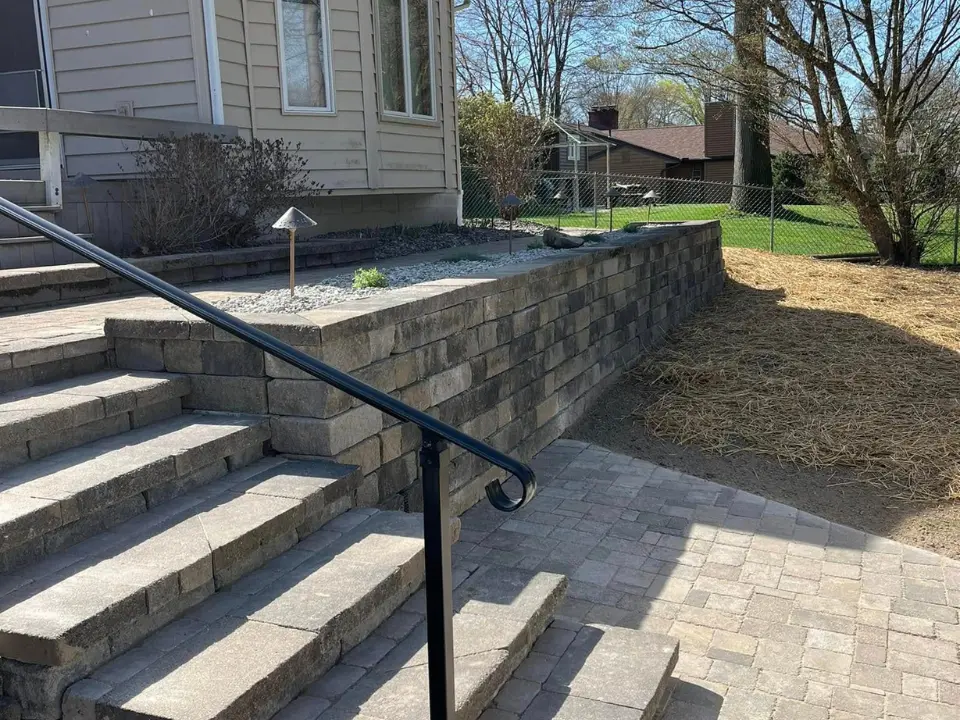 New retaining wall and paver steps with clean stonework and updated layout
